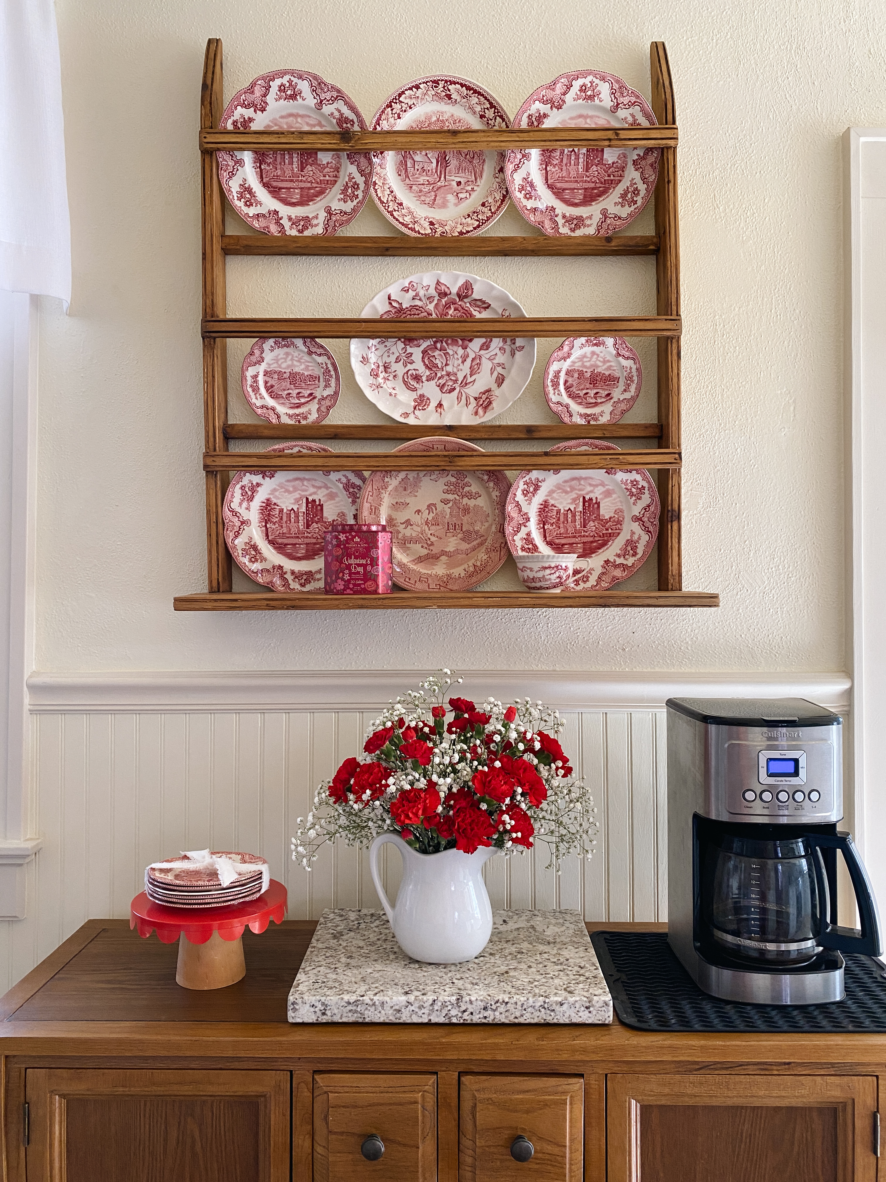 Simple Valentine’s Day decor in a kitchen using red transferware, fresh flowers, and small seasonal accents.