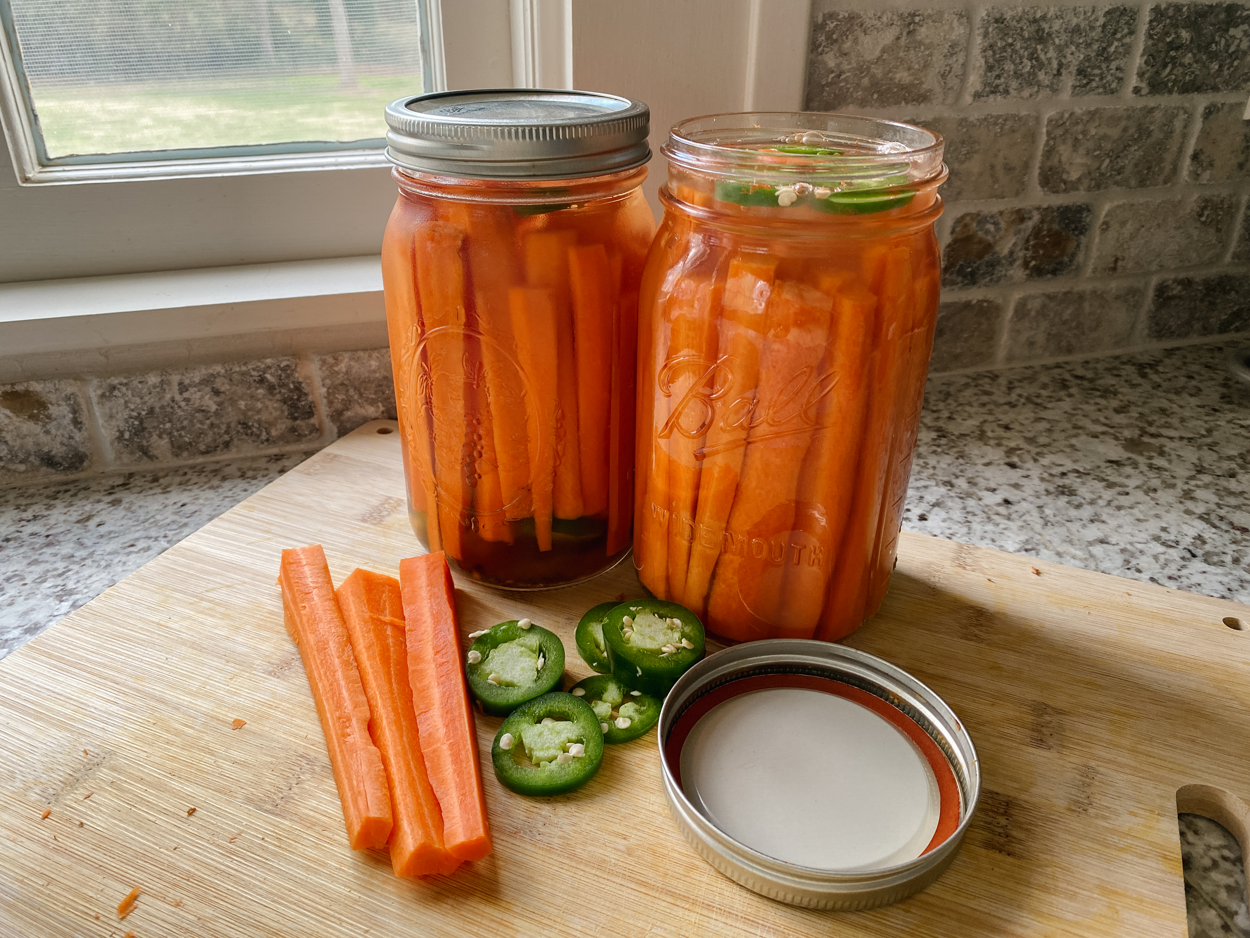 jars of zesty pickled carrots with jalapeño slices on a kitchen counter