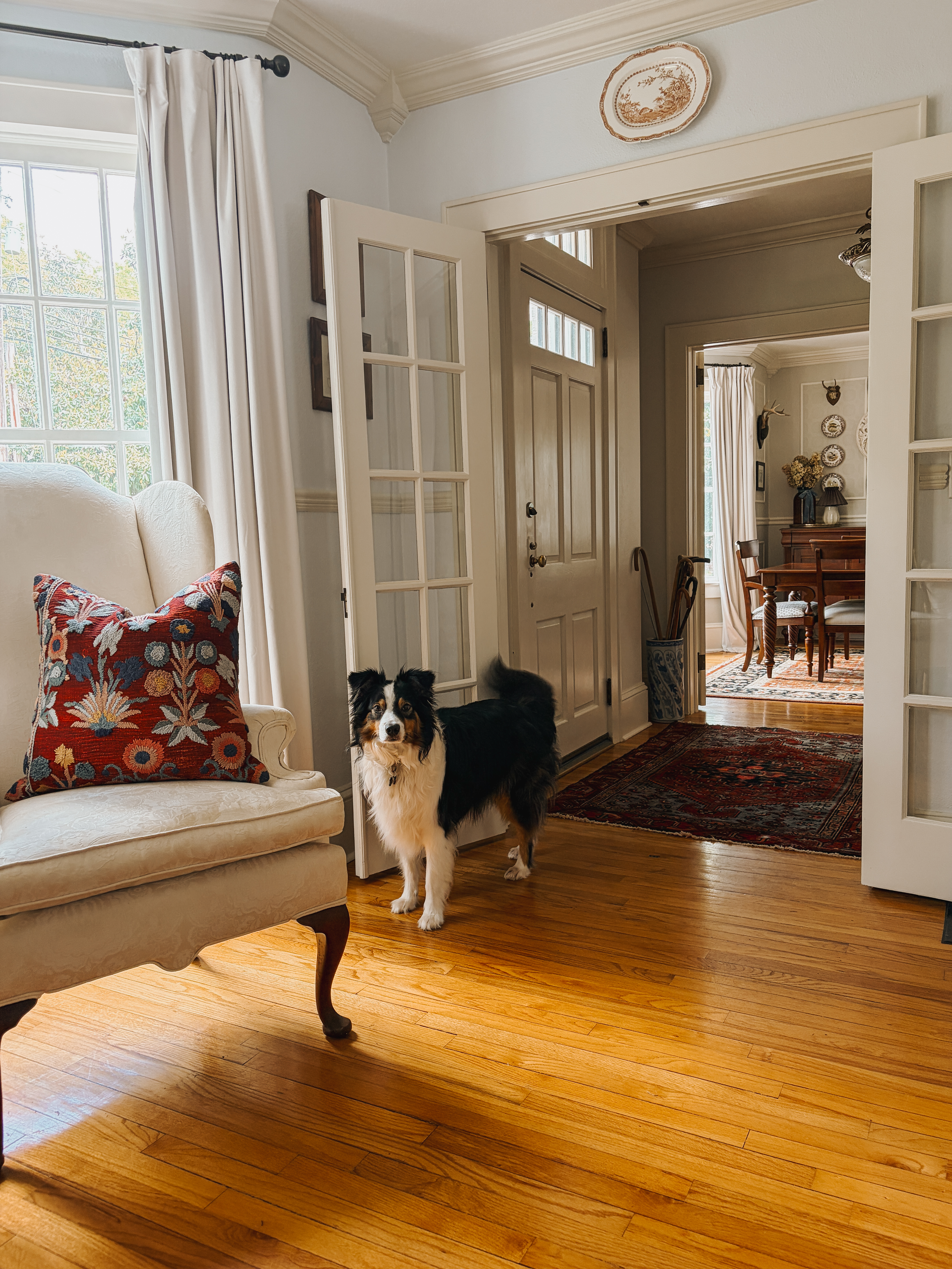 Traditional home design with connected rooms, layered rugs, and warm natural materials.